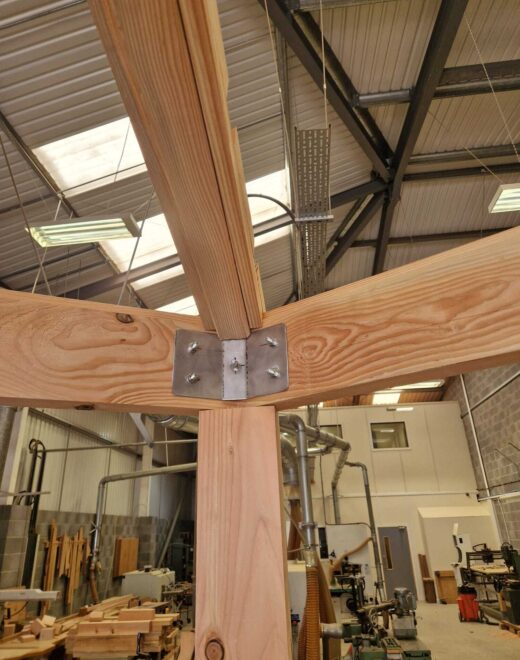 Timber post, beam and metal fixing detail during construction of a bespoke wooden pergola