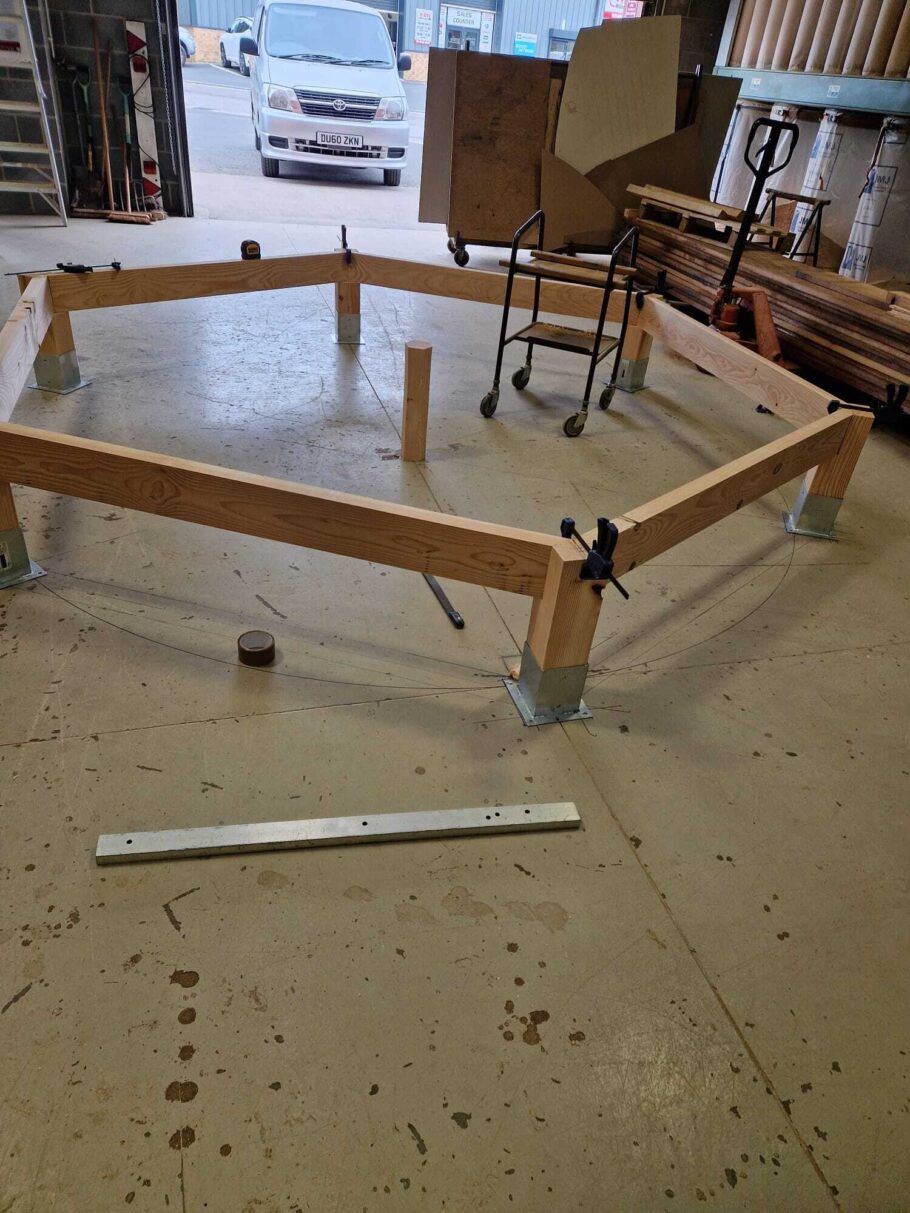 Hexagonal timber pergola frame assembled on workshop floor during the early stages of a bespoke build for a Gloucestershire customer.