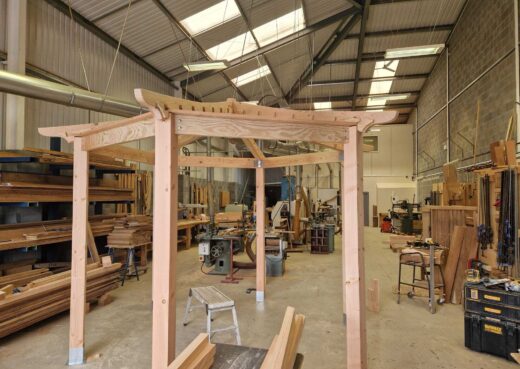 Shaped timber beams and roof framework on the handcrafted bespoke pergola