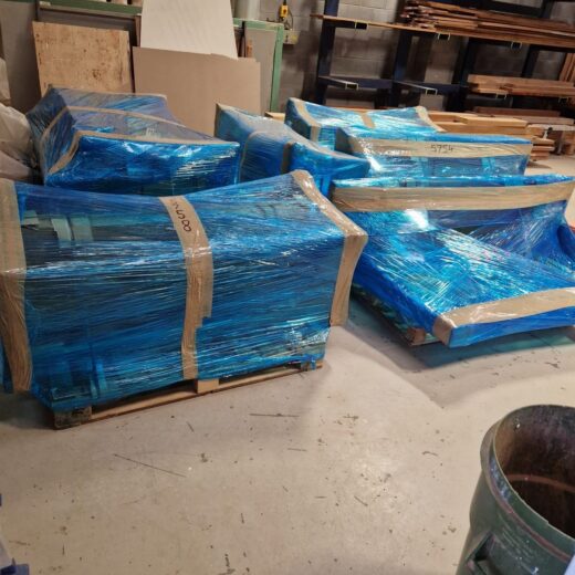 Multiple handmade timber benches secured and wrapped on pallets ready for nationwide delivery