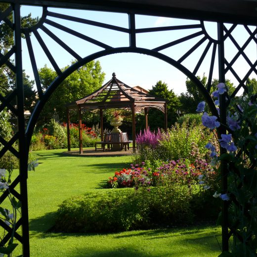 Wooden Gazebo framed by a Garden Pergola