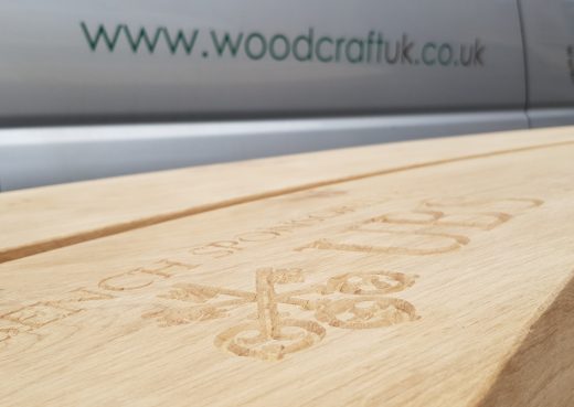 Logo inscription carved into the wooden bench