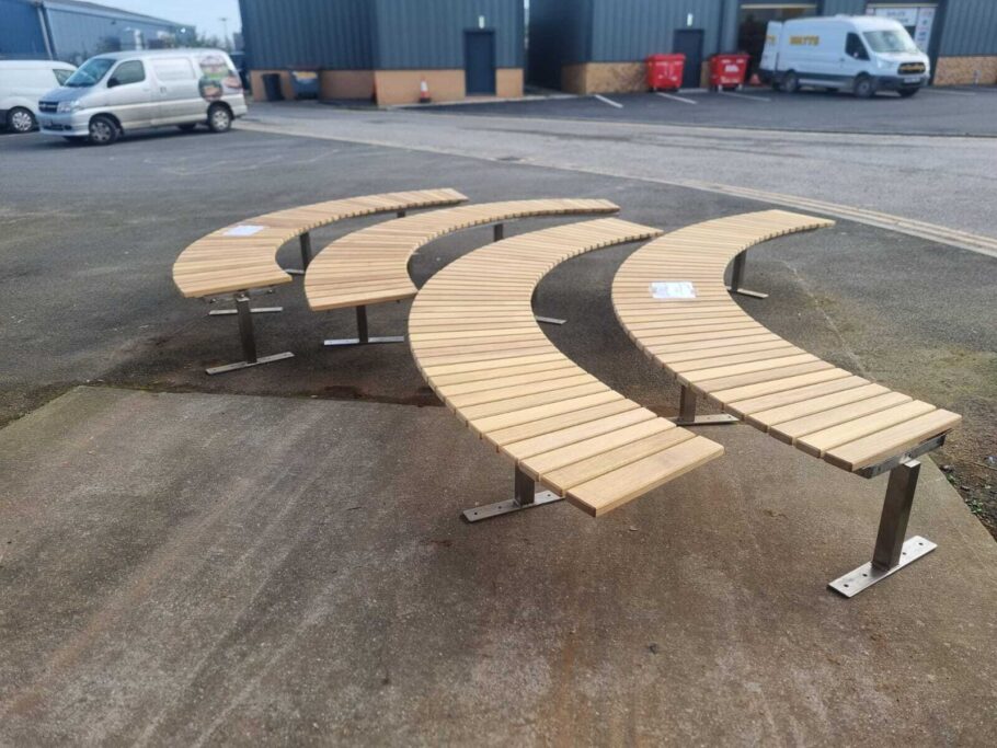 Two stunning curved benches in stainless steel and hardwood, created for an NHS residential site to bring comfort and beauty.