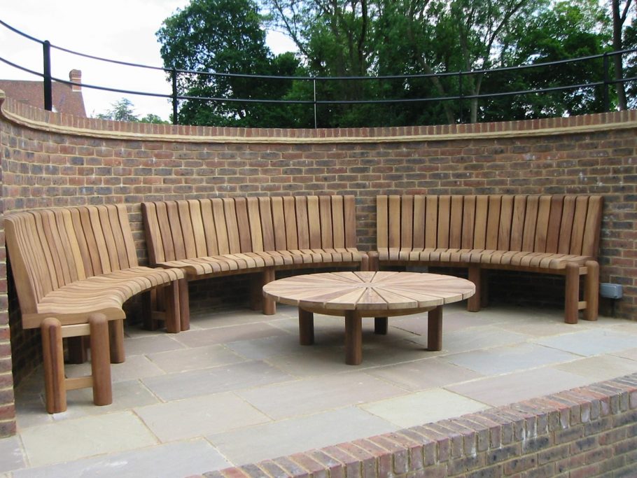 Bespoke curved wooden bench to fit inside a curved spectator area in a set of tennis courts 