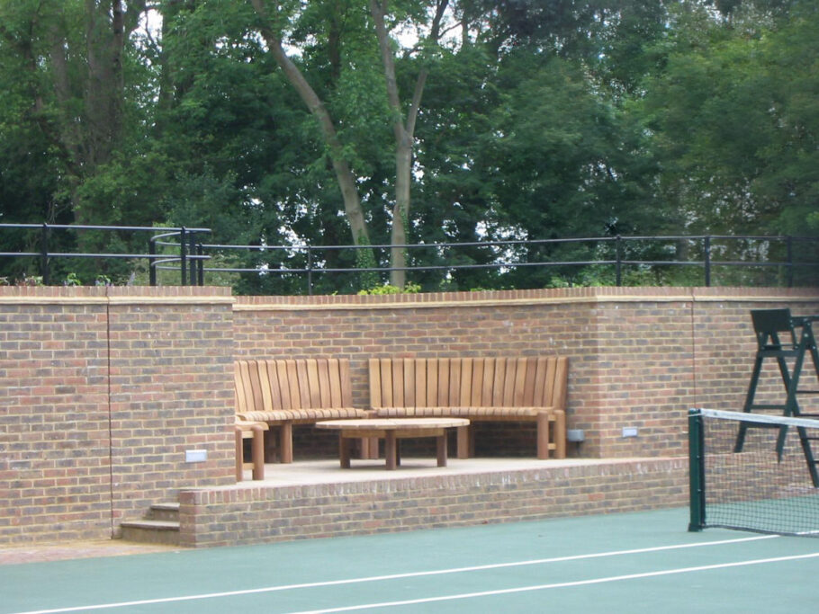 Curved bench set in a tennis court urban project
