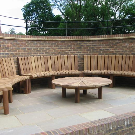 Bespoke curved wooden bench to fit inside a curved spectator area in a set of tennis courts 