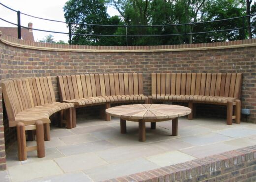 Bespoke curved wooden bench to fit inside a curved spectator area in a set of tennis courts 