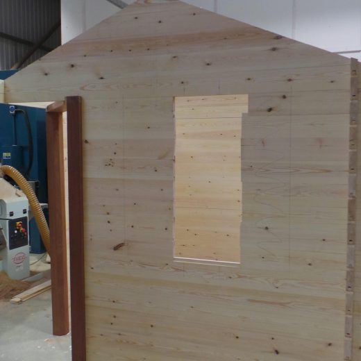 Wooden cabin construction showing side window space