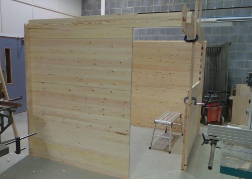 Constructing the walls of the wooden cabin showing doorway forming