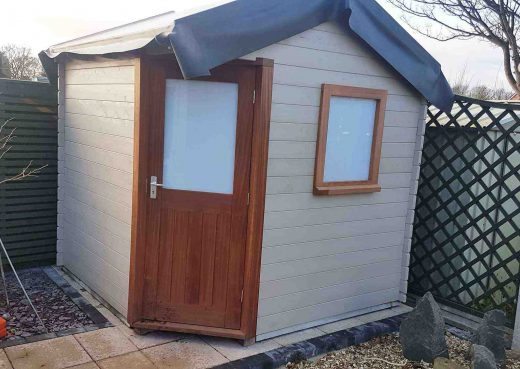 Fitting the EPDM roof of the wooden cabin