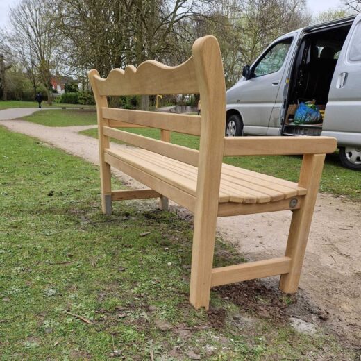 Back view of handcrafted wooden bench during installation in East Park
