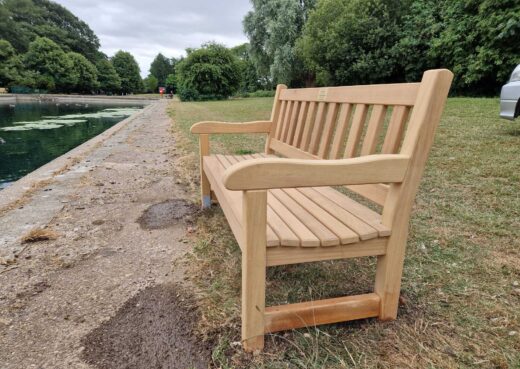 Close view of the handcrafted York bench showing its curved arms and slatted hardwood seat