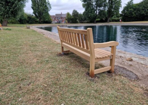 New wooden York memorial bench in its peaceful lakeside setting at East Park, Hull