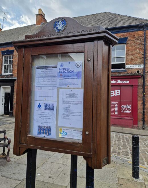 Timber community notice board by Woodcraft in Hedon's historic marketplace surrounded by independent shops.