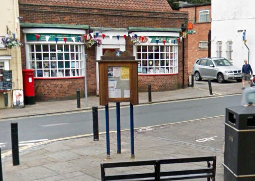 Triangular wooden community notice board displaying local information in Hedon, East Yorkshire.