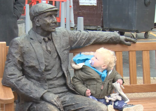 Arthur bronze sculpture seated on a handcrafted Woodcraft York bench outside the Queen's Centre at Castle Hill Hospital in Cottingham.