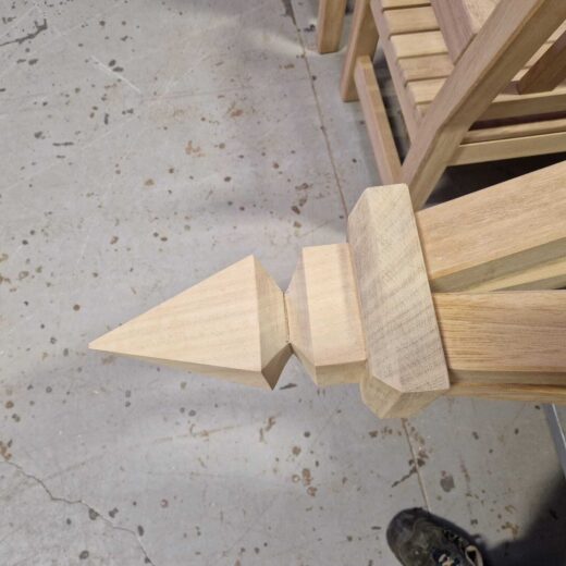 Close-up of the wooden finial on a bespoke garden obelisk during workshop assembly.