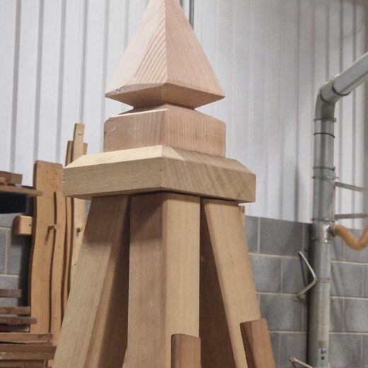Close-up view of the unfinished wooden finial and top section of a bespoke obelisk.