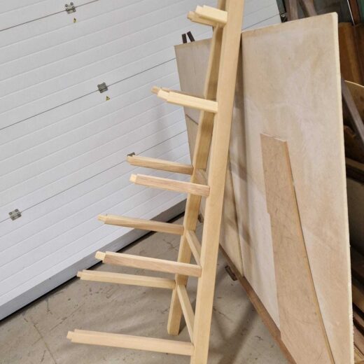 Single obelisk side panel leaning against a wall, showing protruding support arms before full assembly.