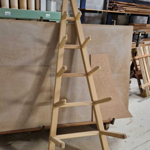 Partially assembled obelisk frame leaning upright, showing the structure and support arms before final assembly.