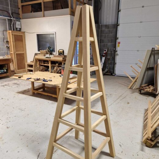 Obelisk frame standing upright, showing the structure and support arms before final assembly.