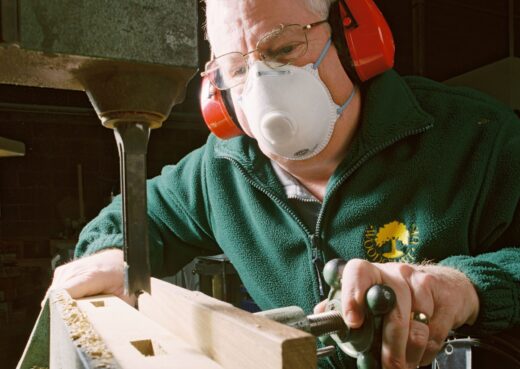 Using a dust mask while operating woodworking machinery