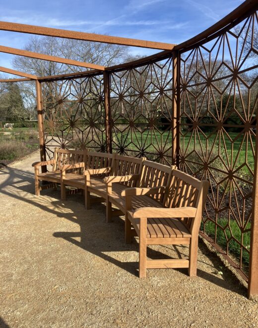 Our curved bench in the sunlight under the pergola at Greenwich Park