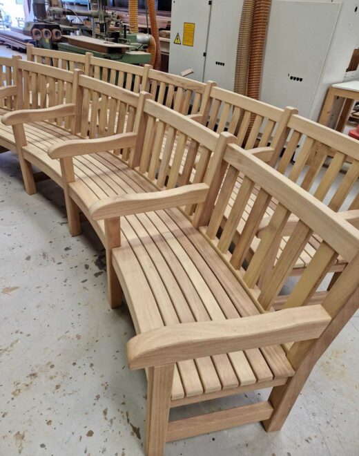 Close view of curved hardwood bench detailing and slatted seating