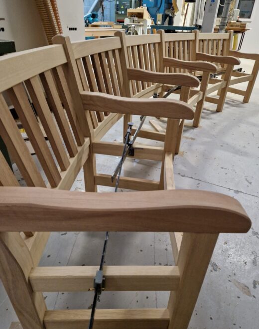 Wooden bench frames aligned and clamped to form curved radius
