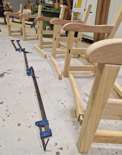Wooden bench frames aligned and clamped to form curved radius