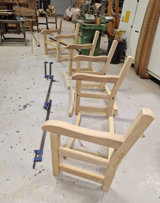 Detailed view of curved bench arms and frame under assembly