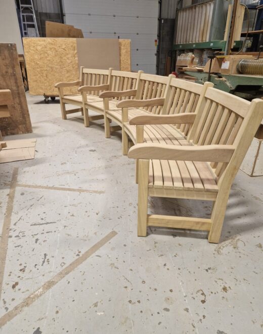 Finished curved York memorial bench with slatted seat in workshop