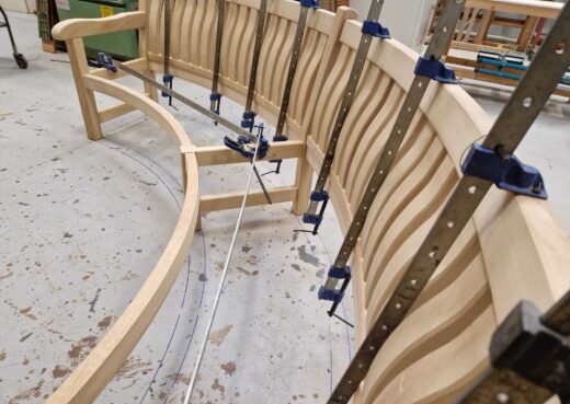Side view of curved back slats being fitted and clamped into position.